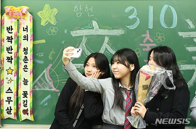 [시흥=뉴시스] 김종택 기자 = 12일 경기도 시흥시 함현고등학교에서 열린 졸업식에서 학생들이 기념촬영 하며 추억을 남기고 있다. 2023.12.12. jtk@newsis.com