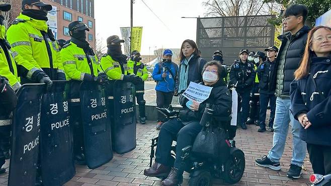 [서울=뉴시스] 13일 경찰에 따르면, 서울 혜화경찰서는 이날 오전 8시30분께 이형숙 서울장애인차별철폐연대 공동대표를 퇴거불응 등 혐의로 현행범 체포했다. 사진은 이날 오전 4호선 혜화역 인근에서 경찰과 대치 중인 이 대표. (사진=전국장애인차별철폐연대 제공). 2023.12.13. photo@newsis.com *재판매 및 DB 금지