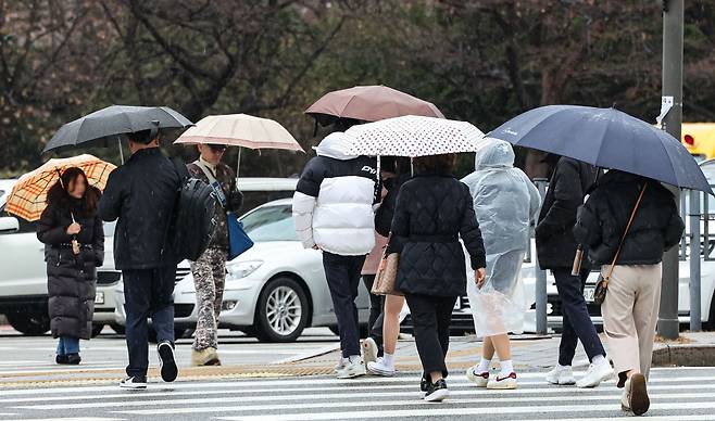 겨울비가 내리는 14일 오전 서울 송파구 잠실역 인근에서 우산을 쓴 시민들이 발걸음을 재촉하고 있다. 2023.12.14/뉴스1