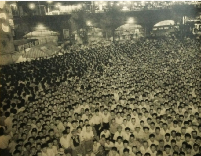 일본 프로레슬링 팬들이 도쿄 신바시역에 설치된 TV로 역도산의 경기를 지켜보고 있다. &nbsp;