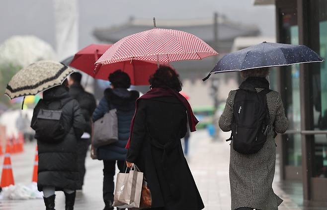 비가 내린 14일 오후 우산을 쓴 시민들이 서울 광화문광장을 지나고 있다. [사진 = 연합뉴스]