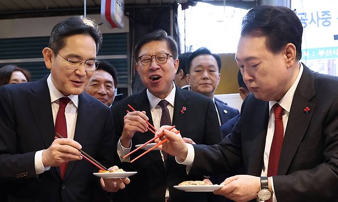 윤석열 대통령이 지난 6일 부산 중구 깡통시장에서 이재용 삼성전자 회장에게 빈대떡을 건네고 있다. 연합뉴스