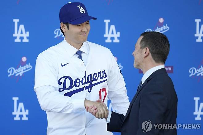 프리드먼 사장과 악수하는 오타니 오타니 쇼헤이(왼쪽)가 15일(한국시간) 미국 로스앤젤레스 다저스타디움에서 열린 로스앤젤레스 다저스 입단 기자회견에서 앤드루 프리드먼 사장과 악수하고 있다. [AP=연합뉴스]