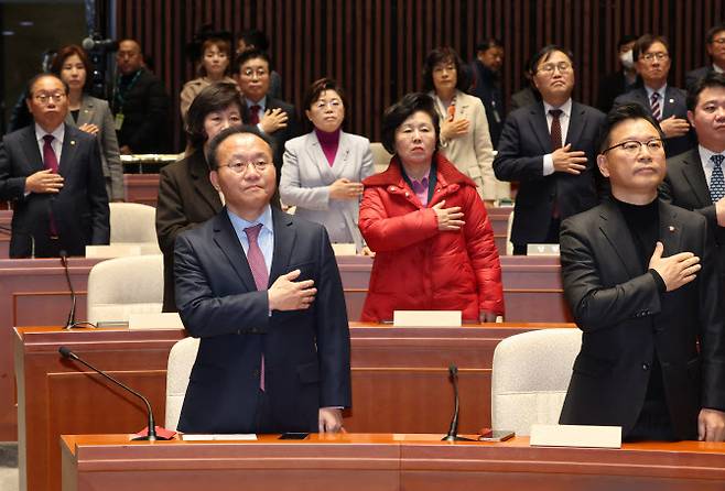 윤재옥 국민의힘 대표 권한대행 겸 원내대표를 비롯한 의원들이 15일 서울 여의도 국회에서 열린 비상의원총회에서 국기에 경례를 하고 있다.(사진=뉴스1)