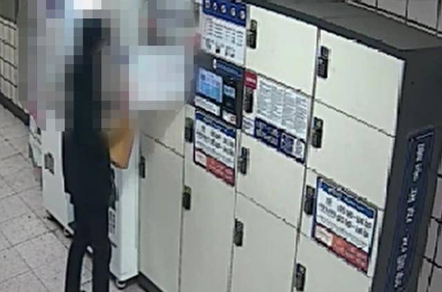 5월 서울 서대문구의 한 지하철역 물품보관함에서 전자책 해킹 사건의 현금수거책으로 활동한 C씨가 거액이 든 종이봉투를 꺼내고 있다. 경찰청 제공