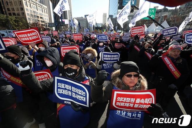 (서울=뉴스1) 박세연 기자 = 대한의사협회 의사들이 17일 오후 서울 종로구 동화면세점 앞에서 열린 의대정원 저지를 위한 제1회 전국의사 총궐기대회에서 구호를 외치고 있다. 2023.12.17/뉴스1  Copyright (C) 뉴스1. All rights reserved. 무단 전재 및 재배포,  AI학습 이용 금지.