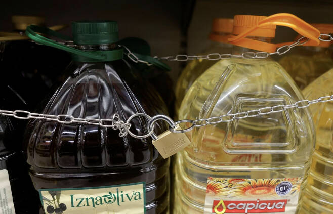 스페인의 한 마트에서 가격 폭등으로 인한 도난을 막기 위해 올리브유와 해바라기씨유를 매대에 묶어 놓은 모습 [로이터]