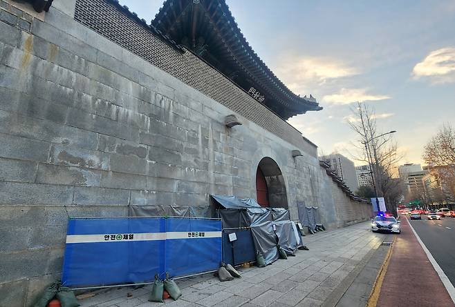 Part of the left wall of the Yeongchumun, the west gate of Gyeongbokgung in Jongno-gu, central Seoul, is covered up to hide graffiti, Monday. (Yonhap)