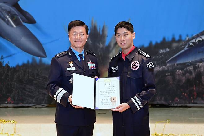 이영수 공군참모총장(왼쪽)이 19일 서울 영등포구 공군호텔에서 열린 2023년 공군 공중사격대회 시상식에서 올해의 탑건으로 선정된 김우영 대위에게 대통령상을 대리 시상 후 기념 촬영하고 있다. 공군 제공