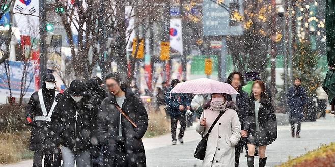 서울 강남구 삼성동에서 19일 시민들이 눈을 맞으며 길을 걷고 있다. 20일에도 전국이 영하권에 머물며 대체로 흐린 가운데 일부 지역에서는 눈이 내릴 것으로 예보됐다. 이충우 기자