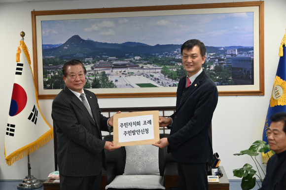 12월18일 오후 서울 종로구 종로구의회에서 '종로구 주민자치회 조례 주민발안 추진위'의 손중호 공동위원장(왼쪽)이 라도균 종로구의회 의장에게 '통 단위 주민자치회 실시'를 골자로 한 조례 신청안을 전달하고 있다. ⓒ시사저널 입수 사진