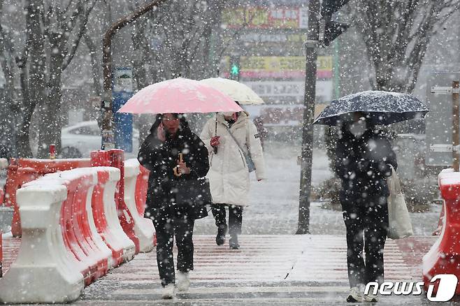 광주와 전남에 많은 눈이 예보된 20일 광주 서구 상무지구에 시민들이 눈을 맞으며 걸어가고 있다.2023.12.20/뉴스1 ⓒ News1 김태성 기자