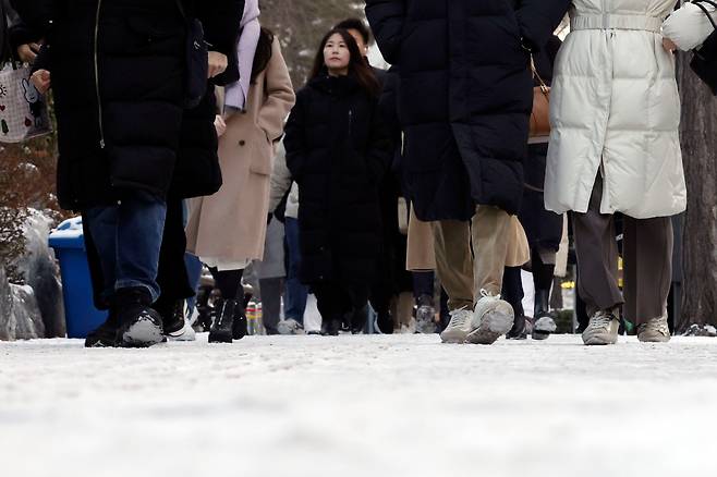 밤사이 내린 눈과 영하권 날씨로 인해 인도가 얼어붙은 20일 오전 서울 강변역 인근에서 시민들이 출근하고 있다. /뉴시스