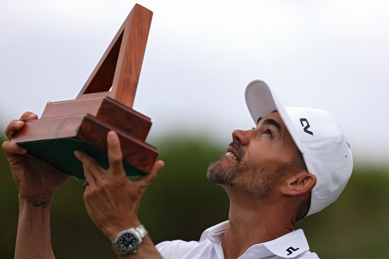 Camilo Villegas of Colombia celebrates with the trophy after winning the Butterfield Bermuda Championship at Port Royal Golf Course on Nov. 12, 2023 in Southampton, Bermuda. [GETTY IMAGES]