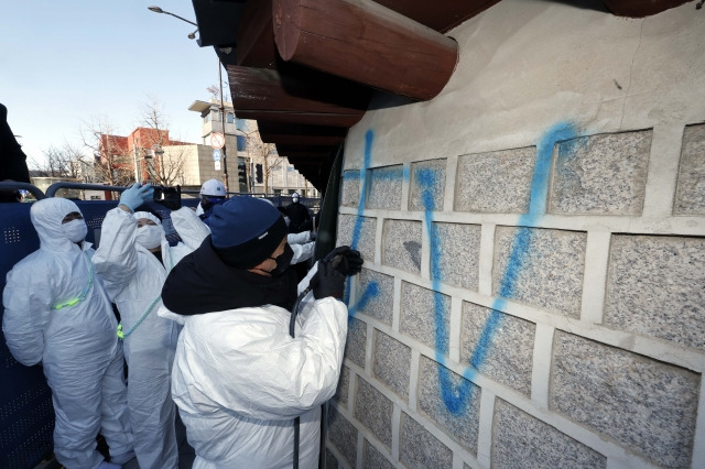 17일 오전 서울 종로구 국립고궁박물관 쪽문 경복궁 담벼락 앞에서 문화재청 관계자들이 전날 누군가가 스프레이로 쓴 낙서 제거 작업을 하고 있다. 연합뉴스