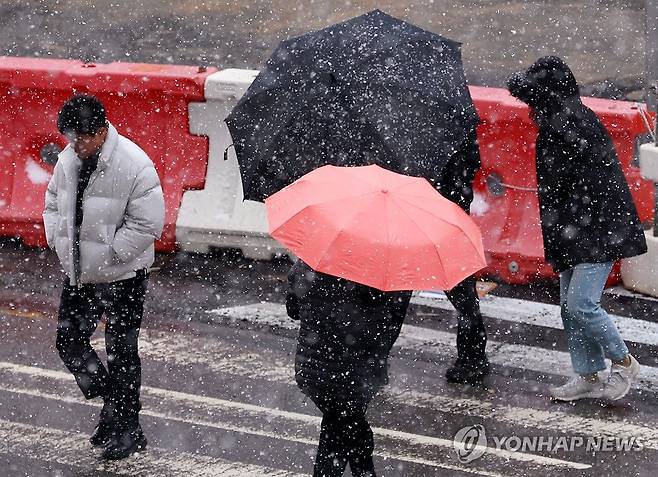 추위 동반한 눈에 움츠린 시민들 (광주=연합뉴스) 조남수 기자 = 광주와 전남 일부 지역에 대설주의보와 한파주의보가 내려진 20일 오후 광주 서구 치평동에서 시민들이 내리는 눈을 맞으며 도로를 걷고 있다. 2023.12.20 iso64@yna.co.kr