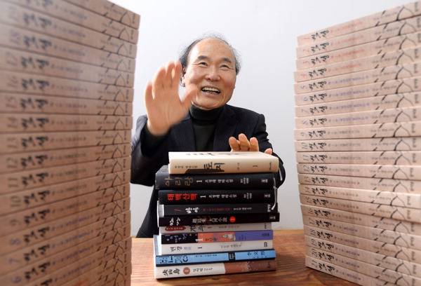 김동민 작가가 지난 16일 경남 진주시 남강변의 자택에서 자신의 대하소설 ‘백성’(전 21권)과 평소 즐겨 읽는 다른 작가의 대하소설을 앞에 두고 손장단을 치며 ‘언가’를 부르고 있다. ‘언가’는 ‘백성’에서 매우 중요한 노래로 등장한다.