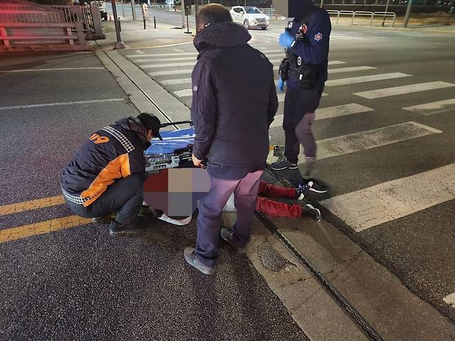 횡단보도에 쓰러져있는 피해자를 119 구급 대원이 구조하는 모습