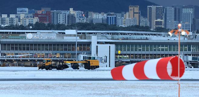 북극발 한파가 몰아친 21일 오후 제주국제공항 활주로에서 한국공항공사 제설차량이 눈을 치우고 있다.[연합뉴스]