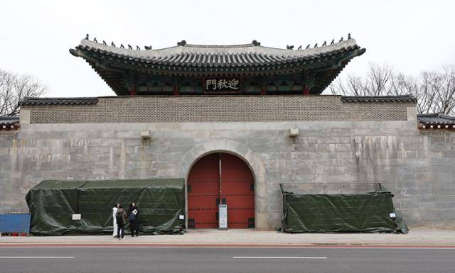 19일 오후 서울 종로구 경복궁 영추문에 스프레이 낙서로 훼손된 담벼락 복구 작업을 위한 가림막이 설치돼 있다. 연합뉴스