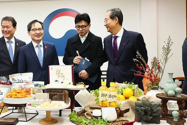 [서울=뉴시스] 한덕수 국무총리가 12일 서울 종로구 정부서울청사에서 전남 고흥산 유자음료, 과일맛 떡 등 가벼운 다과로 구성된 농식품 수출제품을 시식하고 있다. (사진=총리실 제공) 2023.12.12. photo@newsis.com *재판매 및 DB 금지