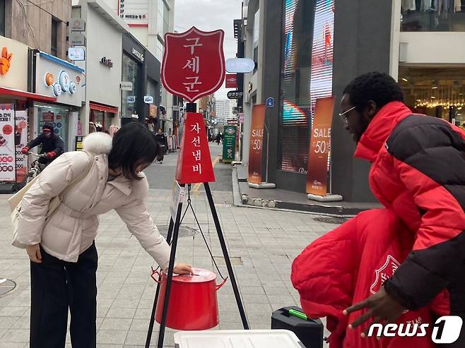 한 시민이 광주 동구 충장로에 마련된 구세군의 자선냄비에 기부를 하고 있다. 2023.12.19/뉴스1 조현우 인턴기자