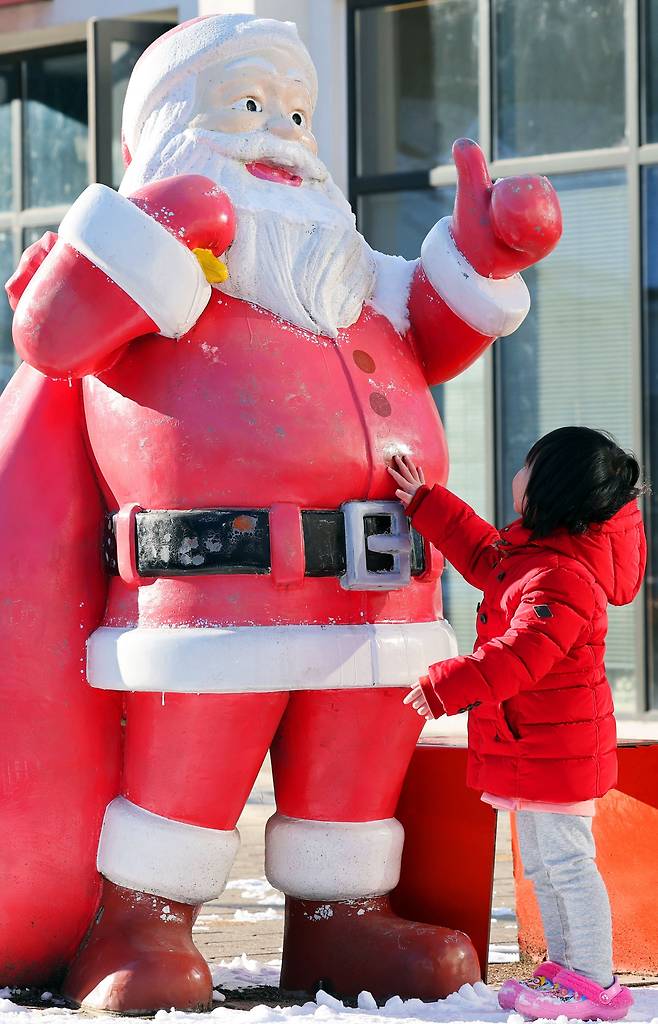 22일 전남 담양군 메타프로방스에서 열린 산타 축제에서 한 아이가 산타클로스 조형물을 만지고 있다./연합뉴스