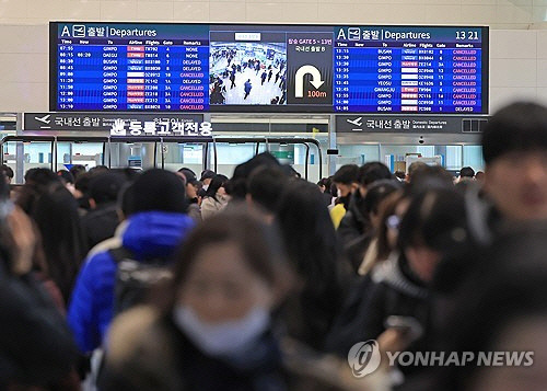 폭설이 내린 22일 오후 제주국제공항 국내선 출발층의 전광판이 지연, 결항을 알리고 있다. [제주=연합뉴스]