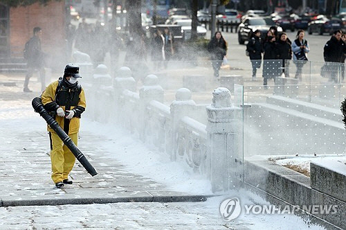 전국 곳곳에 밤사이 눈이 내린 20일 오전 서울역사박물관 앞에서 관계자들이 제설작업을 하고 있다. [연합뉴스]