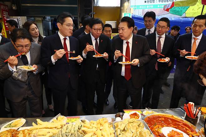 윤석열 대통령이 12월 6일 부산 부평깡통시장의 한 분식집을 찾아 이재용 삼성전자 회장(왼쪽 두번째) 등 기업인들과 떡볶이를 시식하고 있다. | 대통령실사진기자단