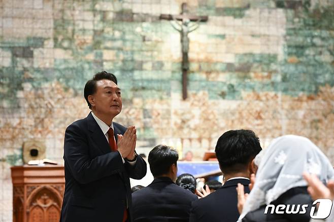 윤석열 대통령이 24일 오후 서울 종로구 혜화동 성당에서 열린 '주님 성탄 대축일 미사'에 참석해 주임신부의 소개에 따라 자리에서 일어나 신도들에게 인사하고 있다. (대통령실 제공) 2023.12.24/뉴스1 ⓒ News1 안은나 기자