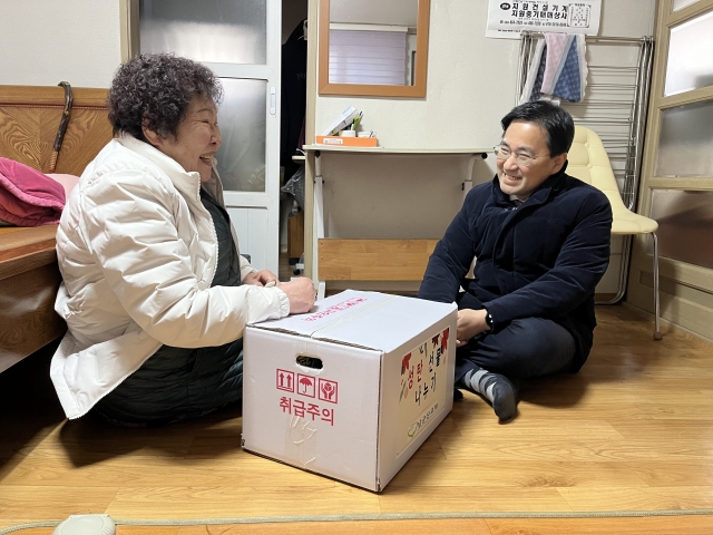 이신사(오른쪽) 남군산교회 목사가 지난 21일 전북 군산 차정복 어르신 집을 방문해 성탄 선물을 전달하고 함께 웃고 있다.