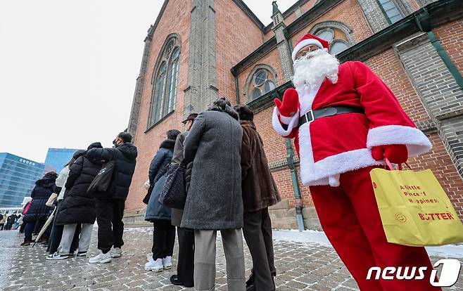 성탄절인 25일 서울 중구 명동성당에서 한 천주교 신자가 산타 복장을 하고 성탄 대축일 낮미사에 참석하기 위해 대기하고 있다. 2023.12.25/뉴스1 ⓒ News1 김도우 기자