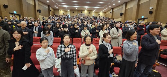 탈북 다큐 영화 '비욘드 유토피아'의 국회 시사회 참석자들이 국민의례를 하고 있다. 장세정 기자