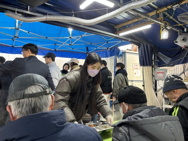 라이트하우스서울숲교회 청년이 25일 서울 영등포구 광야홈리스복지센터에서 노숙인들을 위한 무료 급식을 전달하고 있다.