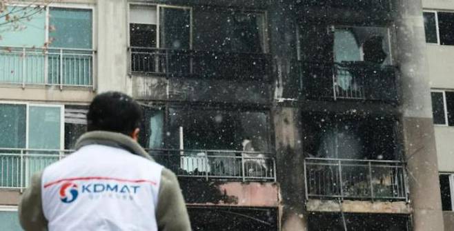 An official from the Korea Disaster Medical Assistance Team (KDMAT) inspects the scene of an accident at an apartment building in Dobong-gu, Seoul, where a fire broke out at dawn on Friday. Two people were killed in the blaze and 32 others were taken to hospitals for treatment of smoke inhalation, fractures and other minor injuries. Yonhap News