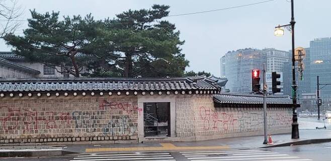 16일 오전 서울 종로구 국립고궁박물관 방향 경복궁 서쪽 담장에 붉은색과 푸른색 스프레이로 ‘영화 공짜’라고 쓴 낙서가 적혀있다.