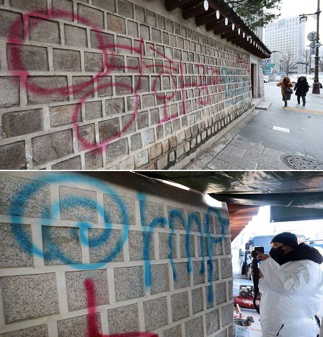 지난 16일 오전 서울 경복궁 국립고궁박물관 방향 담장에 스프레이로 불법 영상 공유 사이트를 표시한 낙서테러가 발생했다. 문화재청은 담장 훼손 현장에 임시 가림막을 설치하고 전문가들과 함께 훼손 현장을  보존처리 약품을 이용해 세척하고 있다. [사진출처=연합뉴스]