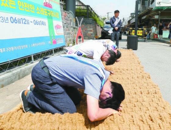 지난 6월 14일 인천시 남동구 소래포구 전통어시장에서 상인들이 자정대회를 열고 신뢰 회복을 약속하며 사과하고 있다. 연합뉴스