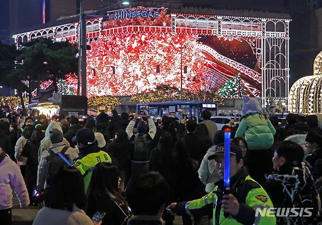 [서울=뉴시스] 김금보 기자 = 경찰이 크리스마스이브인 지난 24일 오후 서울 중구 신세계백화점 앞에서 일방통행, 임시보행로 안내 등 인파 관리를 하고 있다. 2023.12.24.