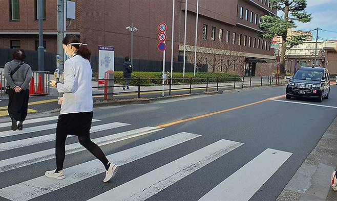 27일 오전 일본 도쿄 신주쿠구의 한 도로에서 차량이 횡단보도에서 3m나 떨어진 정지선을 지키며 보행자가 다 건너가기를 기다리고 있다. 도쿄=강구열 특파원