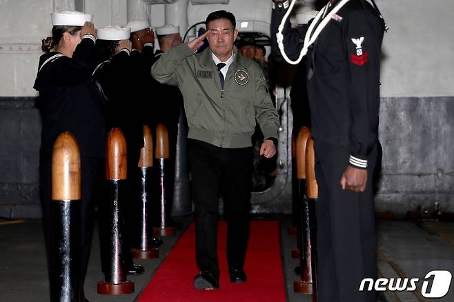 신원식 국방부 장관이 22일 부산 남구 해군작전사령부 부산작전기지에 입항한 미해군 니미츠급 핵추진 항공모함 CVN-70 칼빈슨함에 승선하며 미 해군 장병들의 거수경례에 답례를 하고 있다. (국방부 제공) 2023.11.22/뉴스1