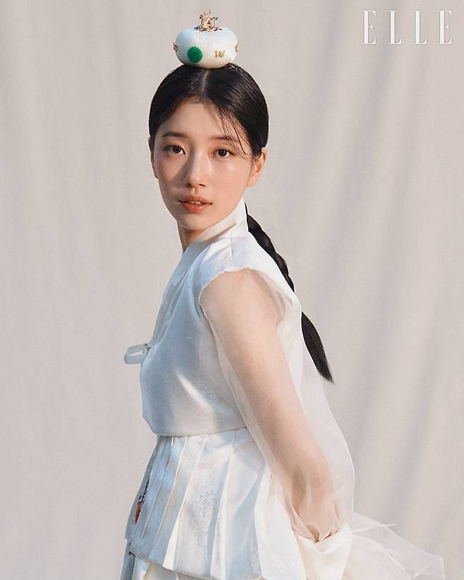 ‘단아하고 검소한 여인의 강인한 지조’를 수지의 눈빛에서 읽어낸 유현화한복. ’검이불루 화이불치(검소하되 누추하지 않고, 화려하지만 사치스럽지 않아야 한다)’ 정신을 살려 흰색을 바탕으로 은은한 문양과 광택 있는 단과 프릴을 더했다.