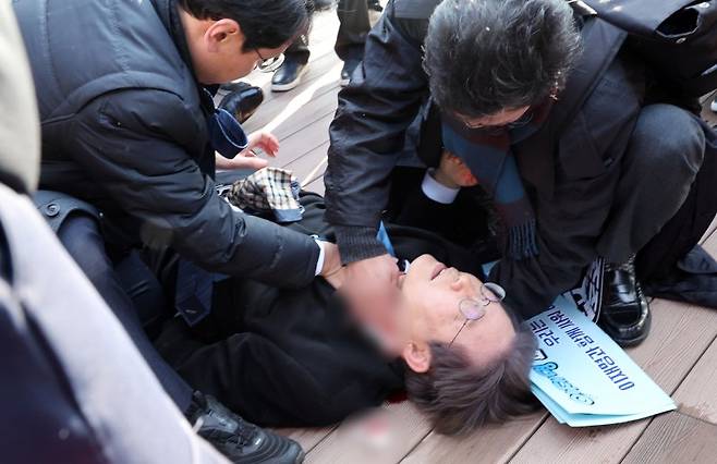 이재명 더불어민주당 대표가 2일 오전 부산 강서구 대항전망대를 방문해 가덕신공항 건설 예정지를 둘러본 뒤 흉기 피습을 당해 쓰러져 있다. 뉴시스 제공