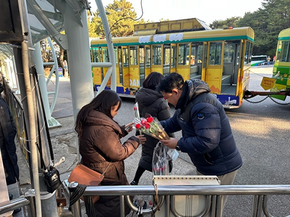 부산관광공사 관계자가 다누비열차 탑승객에게 장미꽃을 증정하고 있다. [사진=부산관광공사]