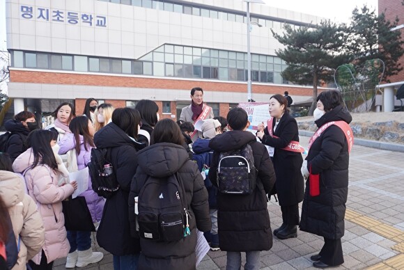 송수연 의원이 제천 명지초등학교에서 학생과 학부모들을 대상으로 ‘요람에서 고딩까지’ 정책에 관한 설문조사를 하고 있다. [사진=제천시의회]
