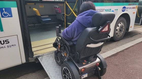 지난달 29일 오전 경기 수원시 팔달구의 한 버스정류장에서 중증 지체장애인 이영아(52)씨가 시내 노선 저상버스에 오르고 있다. 경기도 이동편의시설 기술지원센터에 따르면 버스정류장의 도로 경계석 높이가 18~22㎝ 사이여야 휠체어를 탄 장애인이 안전하게 저상버스에 탑승할 수 있다. 손성배 기자