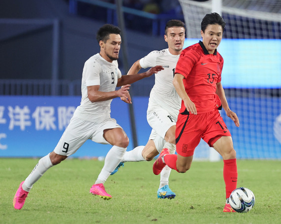 Korea's Jung Ho-yeon, right, dribbles the ball during a Hangzhou Asian Games semifinal match against Uzbekistan at HSC Stadium in Hangzhou, China on Oct. 4, 2023. [YONHAP]