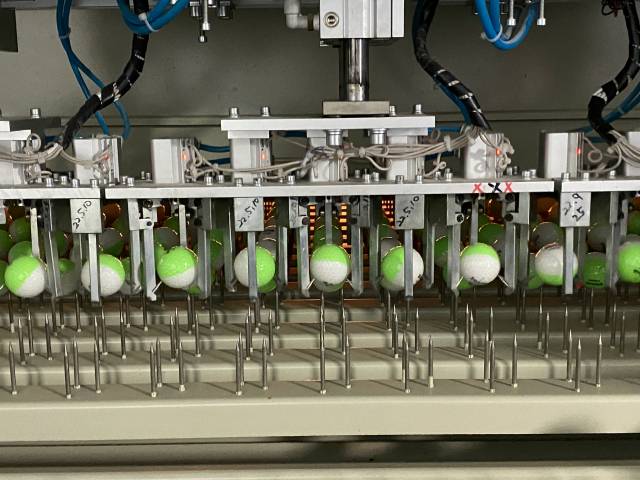 톱 코팅 후 이송장치로 옮겨지고 있는 골프볼.