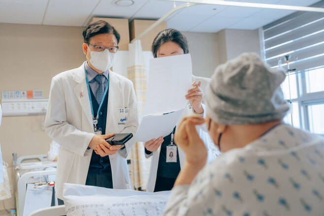 중앙대광명병원 김이수 암병원장(왼쪽)이 유방암 수술을 받은 환자의 건강 상태를 확인하고 있다.   광명중앙대병원 제공